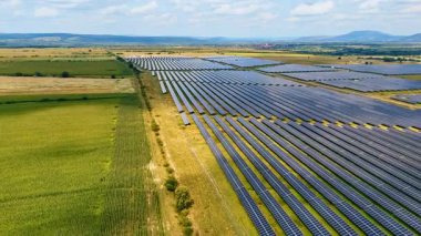 Tarım alanları komşu güneş panelleri sahasında. Yeşil enerji konsepti için fotovoltaik hücreler. Hava görünümü.