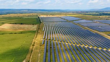 Güneş enerjisini toplayan birçok sıra güneş paneli. Yenilenebilir enerji kavramı. Hava görünümü.