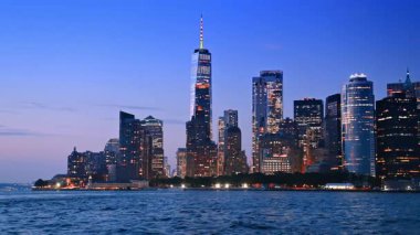 Alacakaranlıkta Manhattan 'ın göz kamaştırıcı silueti. Su manzarasından göz kamaştırıcı şehir manzarası.