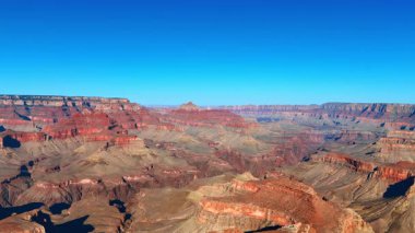 Parlak güneşle aydınlatılmış çıplak kırmızı kayalar. Arizona, ABD 'deki Büyük Kanyon Ulusal Parkı manzarasına hava perspektifi.