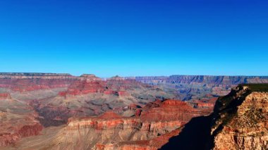 Parlak güneşle aydınlatılmış bitkisiz inanılmaz kırmızı kayalar. Büyük Kanyon Ulusal Parkı, Arizona, ABD açık mavi gökyüzüne karşı.