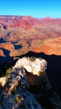 Güneşli bir günde Arizona, ABD 'deki Büyük Kanyon Ulusal Parkı' nın muhteşem manzarası. Kayaların üzerinde İHA görüntüleri. Dikey video.