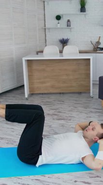 Kilitleme saatinde içeride eğitim gören bir adam. Sportif yaşam tarzı aktif bir adam vücudunu eğitiyor. Dikey video