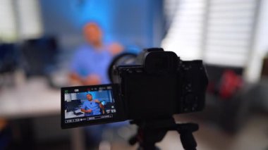 Modern kamerada mavi üniformalı bir erkek doktor var. Kapatın. Tıbbi video günlüğü konsepti. Seçici odak.