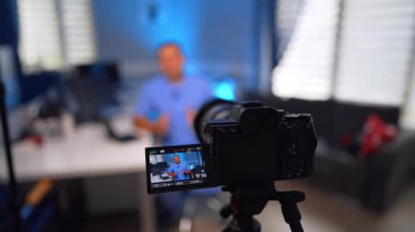 Mavi üniformalı bir adamı kaydeden dijital kameranın görüntüsüne yakından bakın. Doktor video için tıbbi video bloğundan bahsediyor. Seçici odak.