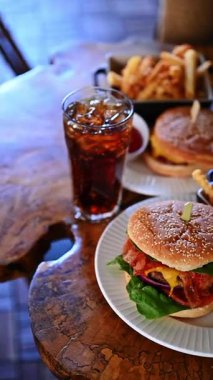 Patates kızartması ve kola ile hazırlanmış klasik çizburger. Kızarmış patates ve soğuk kolayla servis edilen iştah açıcı çizburger..