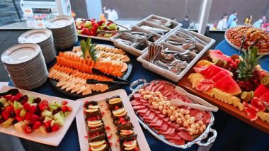 Meyveli, pastalı ve peynirli büfe masası. Dilimlenmiş meyve, hamur işi, peynir ve salamlarla dolu renkli bir büfe..