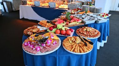 Lüks yolcu gemisi büfesi, meyveler, atıştırmalıklar ve tatlılar. Yolcu gemisinde renkli bir ziyafet masası. Meyve tabakları, hamur işleri, atıştırmalıklar ve aperatiflerle birlikte..