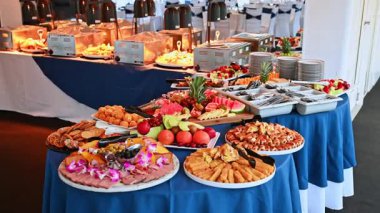 Meyve, hamur işi ve aperatiflerle dolu ziyafet büfesi. Zarif masalarda renkli meyveler, hamur işleri ve atıştırmalıklar sergilenen lüks bir gezi büfesi..