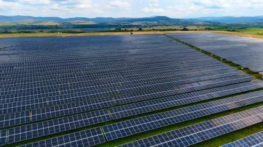 Güneş enerjisi çiftliği yeşil enerji üretiyor. Modern güneş enerjisi panellerinin hava aracı görüntüsü kırsal alanda yenilenebilir elektrik sağlıyor.