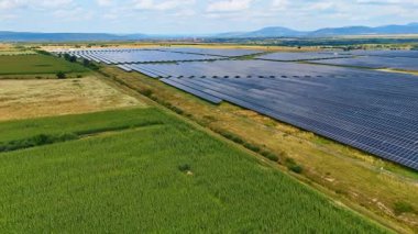 Geniş kırsal alanda güneş enerjisi panelleri. Geniş tarım arazilerindeki güneş enerjisi sistemlerinin hava manzarası temiz sürdürülebilir enerji üretiyor..