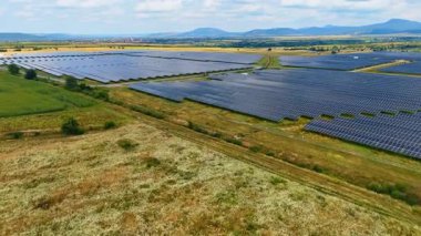 Açık alanlarda büyük güneş paneli kurulumu. Temiz yenilenebilir enerji üretimi için kullanılan geniş bir güneş paneli alanının insansız hava aracı görünümü.