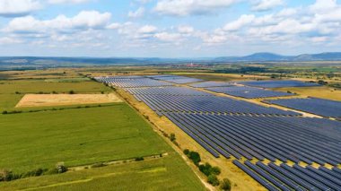 Dağ vadisindeki güneş panelleri. Kırsaldaki güneş panellerinin geniş hava görüntüsü yeşil enerji üretiyor..
