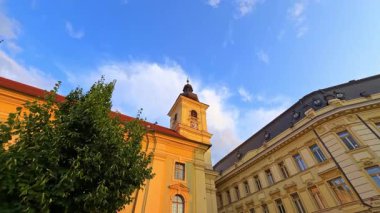 Batan güneşin aydınlattığı tarihi binaların duvarları. Romanya 'nın Sibiu kentinin sokaklarında yürüyorum. Düşük açı görünümü.
