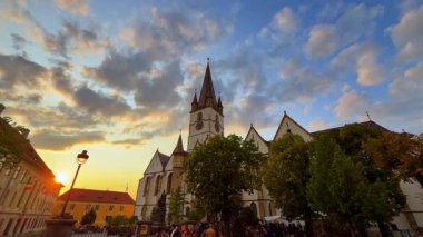Sibiu, Romanya, 17 Temmuz 2025: Gün batımında Romanya 'nın Sibiu kentinin sokaklarında yürüyün. Saint Mary katedralinin tepesinden alçak açılı görüş..