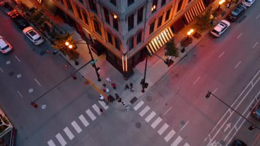 Şikago, ABD, 29 Haziran 2025: İnsansız hava aracı Chicago caddesini aydınlatılmış binalarla çevrili bir kavşakta geçiyor.