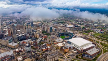 Detroit gökyüzü bulutların üzerinden Comerica Park ile kaplı. Detroit şehir merkezinin insansız hava aracı görüntüsü ve Comerica Park stadyumu kısmen bulutlarla kaplı..