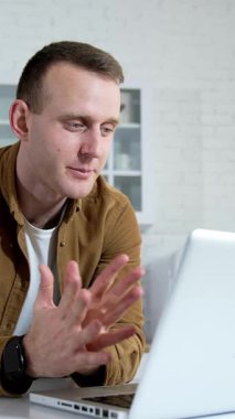 Evde dizüstü bilgisayarda çalışan Freelancer. Genç işadamı evde oturmuş dizüstü bilgisayarla çalışıyor.