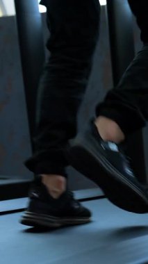 Kyiv, Ukrayna, 2 Mayıs 2025: Spor kulübünde erkek eğitimi. Spor salonunda koşu bandında koşan atletik ayakları kapatın.