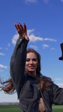 Doğada mikrofonla şarkı söyleyen bir kız. Doğada mikrofonla şarkı söyleyen genç bir kadın.