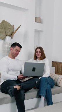 Kanepede oturan insanlar bilgisayara odaklanmış. Meslektaşlar rahat koşullarda çalışırlar. Dikey video