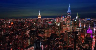 Geceleri modern Manhattan 'ın popüler gökdelenleri. İnsansız hava aracı görüntüleri muhteşem bir aydınlatmayla şehrin üzerinde yükseliyor..