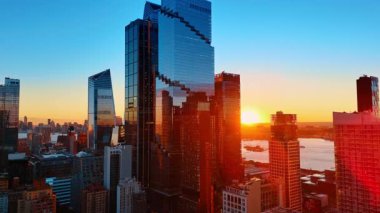 Güneş, Manhattan 'ın cam gökdelenlerinin arkasına saklanıyor. Altın saatinde harika bir New York. Hava görünümü.