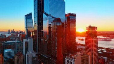 Doğu Nehri 'nin rıhtımındaki modern gökdelenlere doğru uçuyorlar. Bir yolcu gemisi nehir kenarında hareket ediyor. New York, ABD 'de gün batımı.