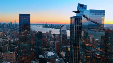 Modern New York 'un nehir kıyısındaki cam gökdelenlerine gidiyoruz. Gün batımında muhteşem metropol manzarası.