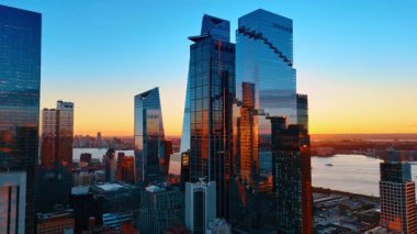 New York 'un yüksek katlı camları batan güneşi yansıtıyor. İnsansız hava aracının altın saatinde çarpıcı bir şehir.