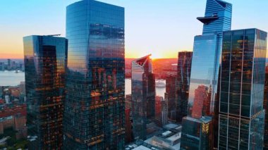 Metropolis 'in cam cephelerinde pencereleri açık uçmak. Nehrin arka plandaki su manzarası. New York 'ta altın saat.