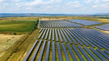 Güneş panelleri yeşil enerji üretiyor. Güneş panelinin birden fazla sırasının drone fotoğrafı temiz ve yenilenebilir enerji üretmek için güneş ışığını yakalıyor.