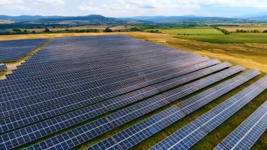 Kırsal alanda fotovoltaik güneş panelleri. Yenilenebilir enerji üreten kırsal yeşil bir arazide düzenlenmiş fotovoltaik güneş panellerinin hava görüntüsü.
