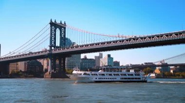 New York, ABD, 9 Ağustos 2025: New York 'taki Manhattan Köprüsü' nün altından geçen bir yolcu gemisi. Beyaz bir yolcu gemisi Manhattan Köprüsü 'nün altından geçiyor. Arkasında New York' un silüeti var..