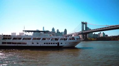 New York, ABD, 9 Ağustos 2025: New York 'ta Manhattan Köprüsü altında yelken açan büyük yolcu gemisi. Beyaz bir yolcu gemisi Manhattan Köprüsü 'nün altından geçiyor ve arka planda New York var..