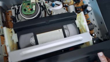 VHS kaydedici oynatıcının içinde. Kapatın. Parmak düğmeye basar ve kaset fırlar..