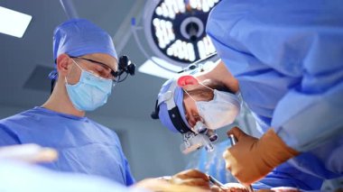 Cerrahi lalelerdeki doktorlar sinir cerrahisinde çalışırlar. Beyin cerrahisi yapan odaklanmış doktorlara düşük açılı bakış açısı.