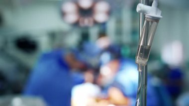 Damardan serum fizyolojik solüsyonu verin. Kapatın. Doktorlar işlemleri bulanık arkaplanda gerçekleştirir.