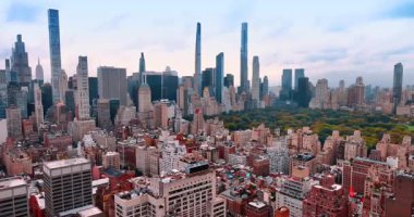 New York, ABD 'deki Central Park' ı çevreleyen mimariye bakın. Manhattan 'ın gökdelenleri bulutlu gökyüzüne karşı.