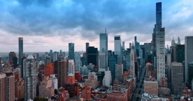 Manhattan, New York, ABD 'nin yoğun şehir manzarasının üzerindeki uçuş. Büyük Elma 'nın görkemli gökdelenleri bulutlu gökyüzüne karşı.