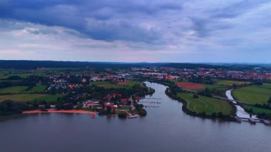 Marina ve rıhtımın insansız hava aracı fotoğrafı. Marina ve teknelerin kırsal ve suyla çevrili hava akşam manzarası.