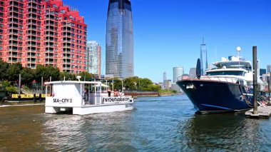 Jersey City, ABD, 1 Temmuz 2025: Çeşitli tekneler Jersey City 'deki East River' ın dar kısmından geçiyor. Manhattan 'ın gelecekteki gökdelenleri.