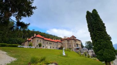 Busteni, Romanya, 17 Temmuz 2025: Güzel bir Cantacuzino Şatosu olan yeşil tepe. Romanya 'nın görkemli toprakları alçak açıdan bakıldığında.