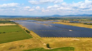 Güneş panelleri ile kaplı kırsal alanın geniş bir bölgesi. Fotovoltaik (PV) hücreler sürdürülebilir enerji üretimi için kullanılır. Hava görünümü.