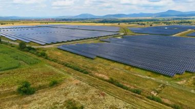Kırsal bölgedeki güneş paneli çiftliği boyunca uçmak. Çevre dostu enerji üretimi.