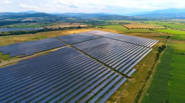 Güzel kırsal kesimlerdeki fotovoltaik hücreler. Çiftlik üzerinde insansız hava aracı uçuşu yeşil enerji üretimi için güneş enerjisi topluyor.