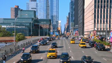 New York, ABD, 5 Ağustos 2025: Arabalar ve sarı taksi çok şeritli yoldan yaklaşıyor. Arka planda çok büyük binalar var. New York, ABD.