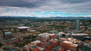 Denver, ABD, 28 Temmuz 2025: Denver, Colorado, ABD 'nin modern şehir manzarası. Mavi gökyüzü gri bulutlarla kaplıdır. Arkaplanda dağ aralığı.