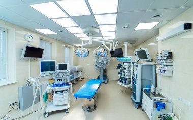 Robot sistemi ve monitörleri olan modern işletim odası. Robot cerrahi sistemi, lambaları ve monitörleri olan modern hastane ameliyathanesinin geniş görüşü.