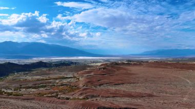 Yosun ve kertenkeleli Rocky Vadisi. İHA uçuşu Death Valley, California, ABD 'de. Güzel mavi gökyüzü, kabarık bulutlar manzaranın üstünde.